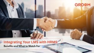 Professionals shaking hands to represent LMS and HRMS integration with GroomLMS