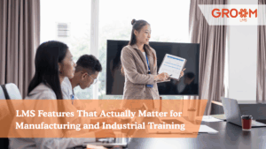 Professional corporate training session with employees attending a presentation on LMS features for manufacturing and industrial training, branded with GroomLMS.