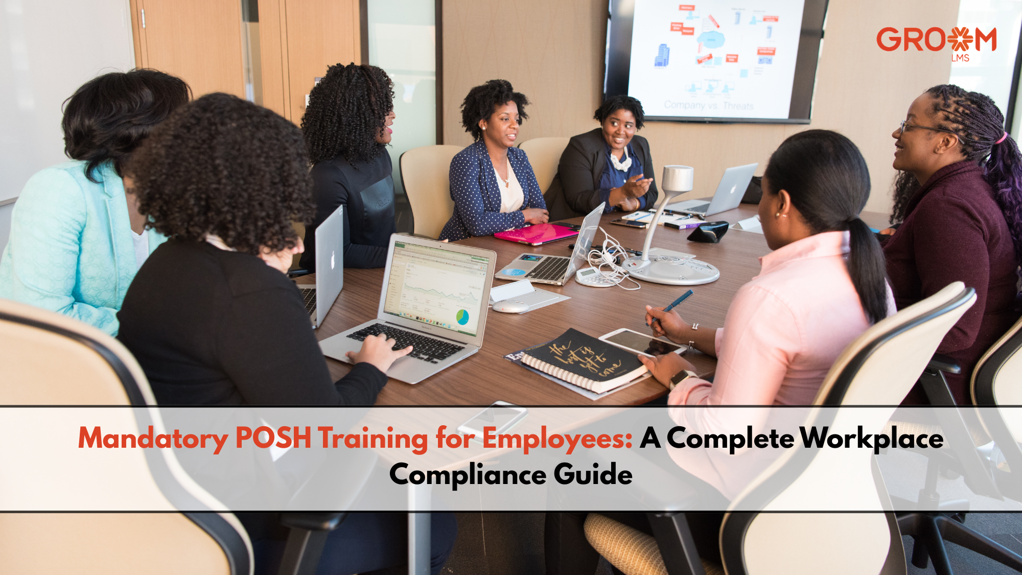 Employees attending a mandatory POSH training session in a conference room with laptops and a presentation on workplace compliance.